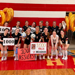 volleyball team poses with "1,000" signs