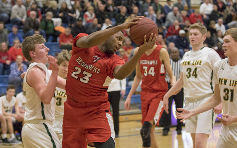 Minnehaha Academy senior JaVonni Bickham pulls down a rebound against New Life Academy Friday night in St. Paul. The Redhawks defeated the Eagles 77-34 in the Class 2A, Section 4 final. Photo by Jeff Lawler, SportsEngine