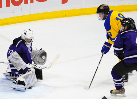 Thief River Falls' Tanner Nessen (19) looks for a rebound as New Ulm's Brach Kraus makes one of his 33 saves. Photo by Adam Crane