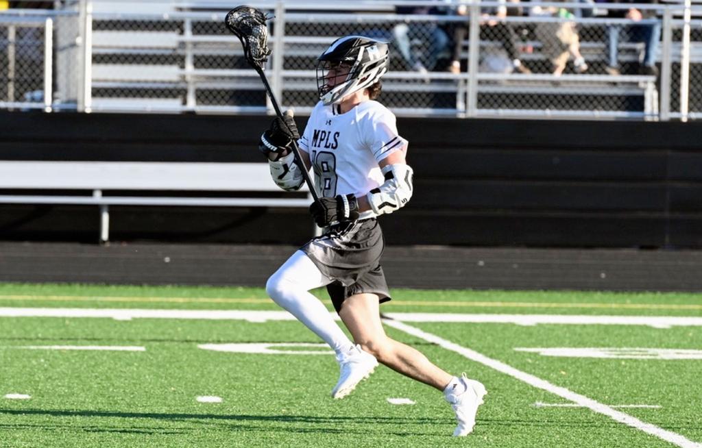 Minneapolis Boys High School Lacrosse player streaks up the sideline during a game