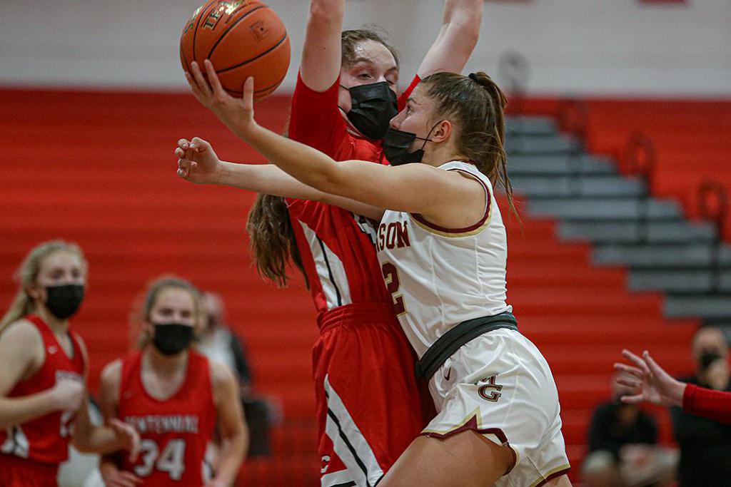 Maple Grove senior Kylie Baranick (12) took the ball to the basket against Centennial's Jenna Guyer in the first half. Baranick led the Crimson with 14 points. Photo by Mark Hvidsten, SportsEngine