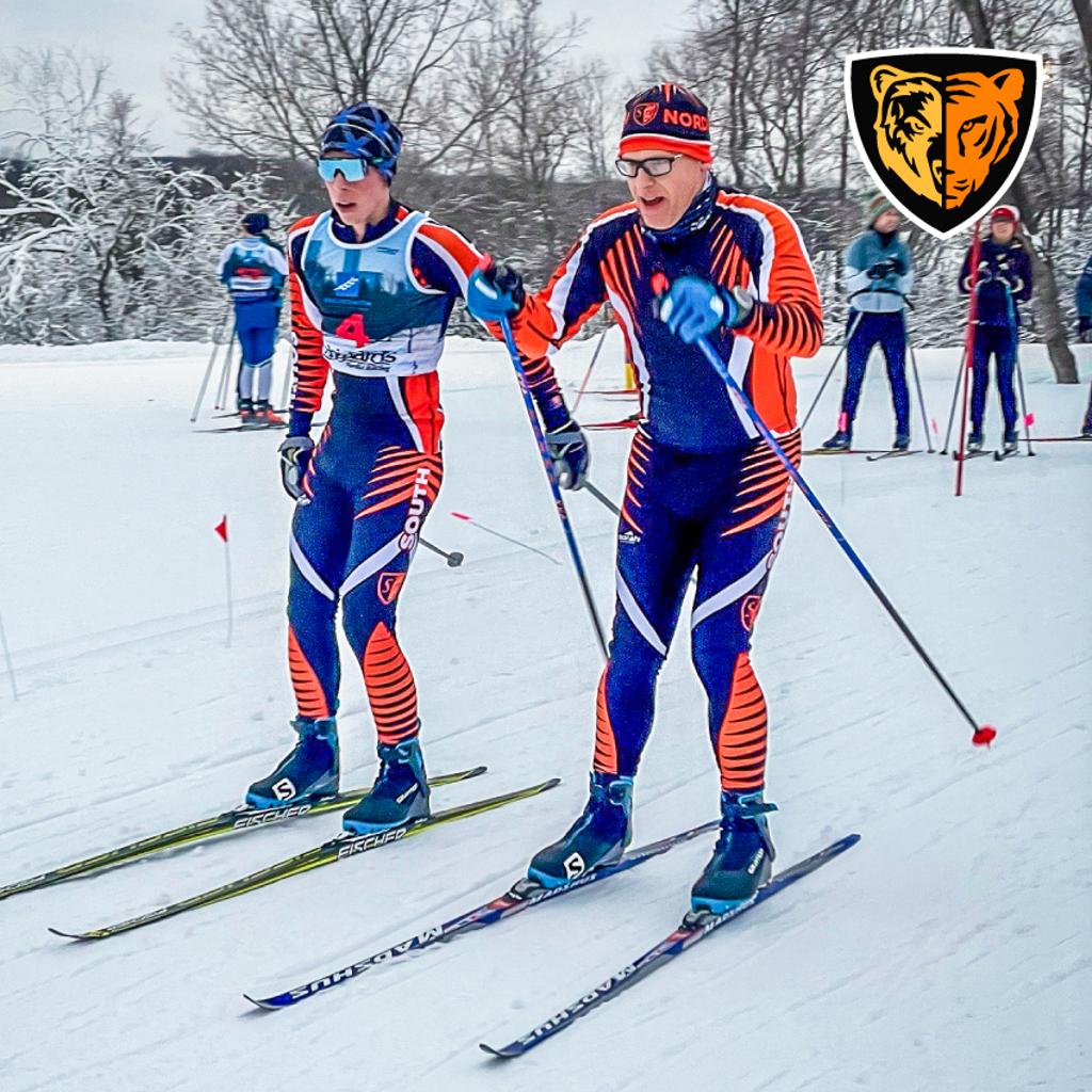 Image of TNT Nordic Skiers getting started with their relay event featuring Coach and athlete pair
