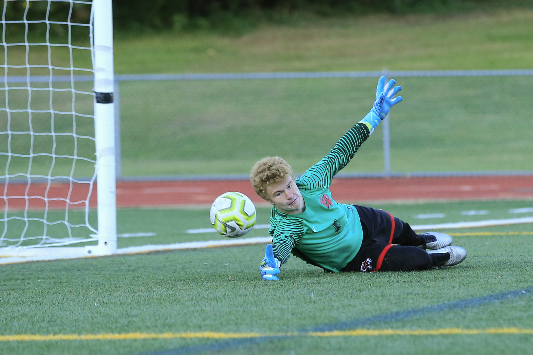 Eden Prairie goalkeeper Steven Mattison (1) dives to make a save in a Lake Conference tilt against Minnetonka Thursday evening. The Eagles fell to the Skippers 1-0 in Eden Prairie. Photo by Jeff Lawler, SportsEngine