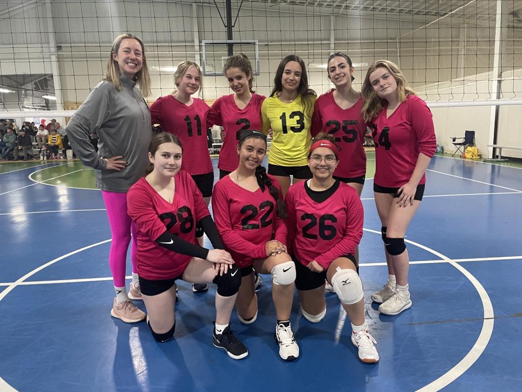 volleyball players and coach in a gymnasium