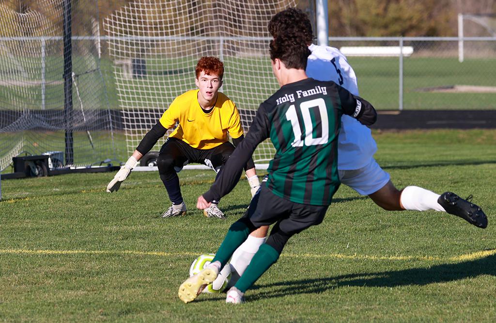 Providence Academy goalkeeper Ben Martin keeps an eye on the ball as defender Andrew Vos (5) clears it from Charlie Fice (10). Martin and the Lions tallied their eleventh shut out this season in a 1-0 win over Holy Family. Photo by Cheryl A. Myers, Sports