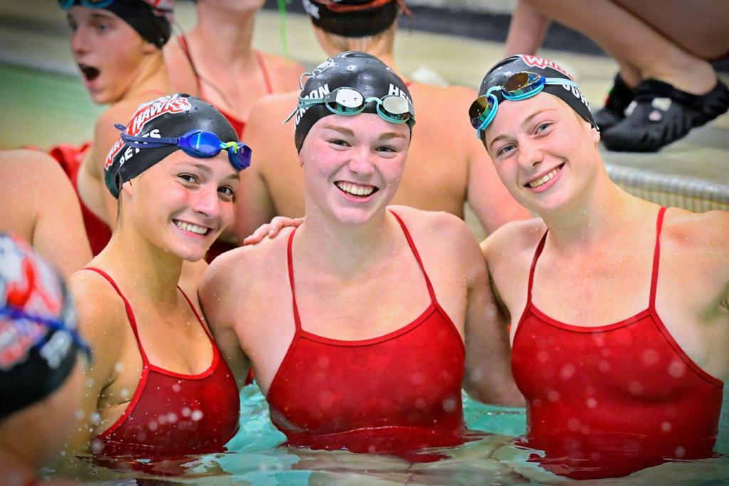 three swimmers in pool