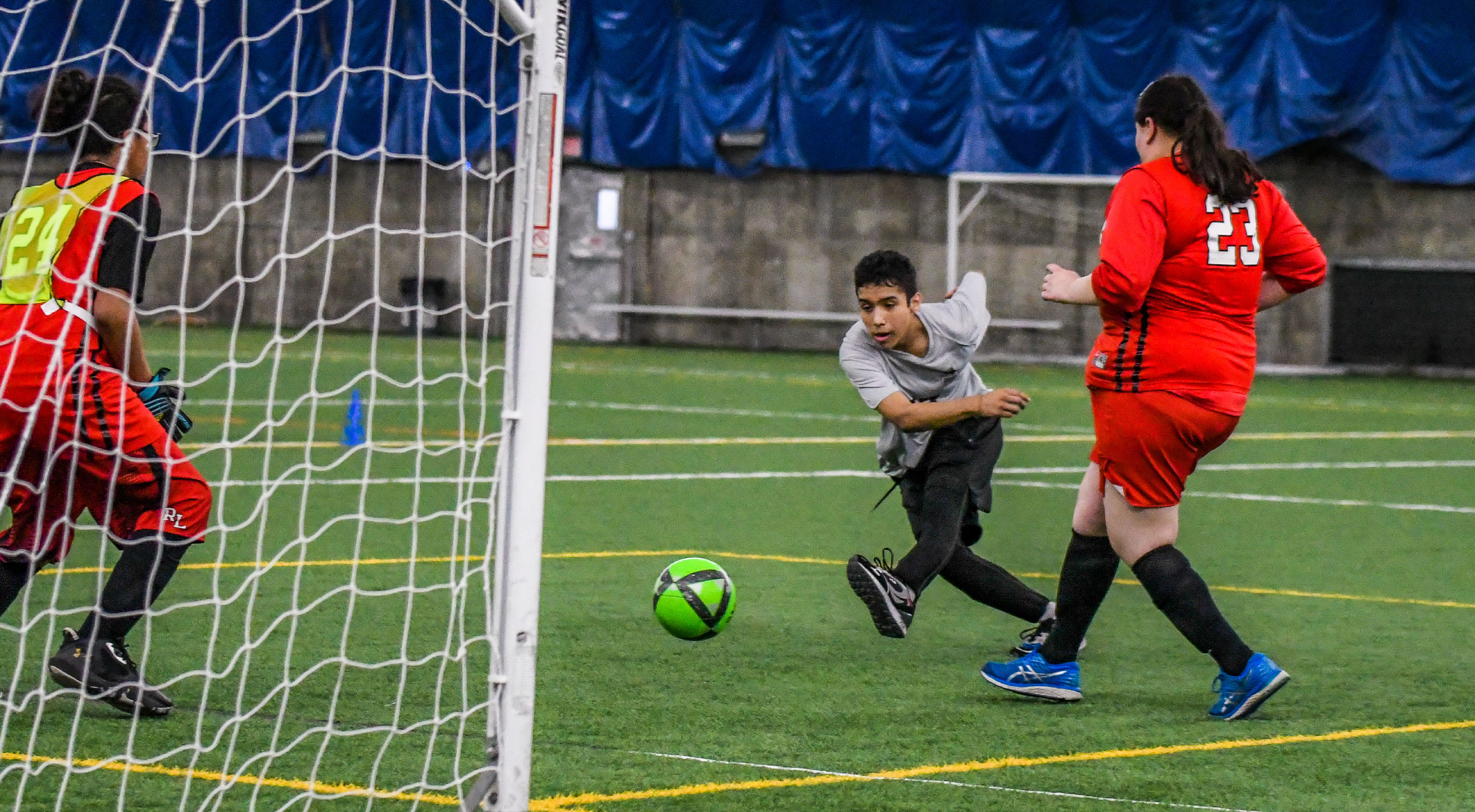 Image of a Minneapolis Roosevelt Adapted Soccer player in action during a game as he kicks the ball to the corner of the goal.