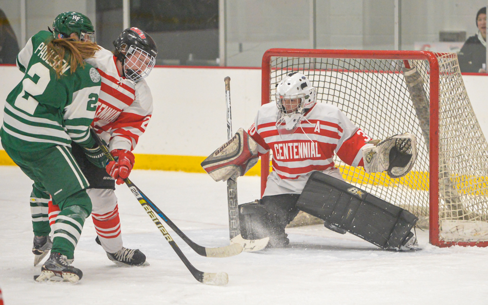 Holy Family Catholic senior forward Sydney Paulsen takes a shot on goal against Centennial goaltender Anna Gilgosch. The Fire defeated the Cougars 3-0 Thursday night. Photo by Earl J. Ebensteiner, SportsEngine