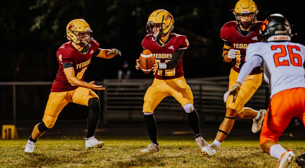 Roosevelt Football quarterback is about to hand the ball to his running back during a night game at Al Gowans Stadium vs South