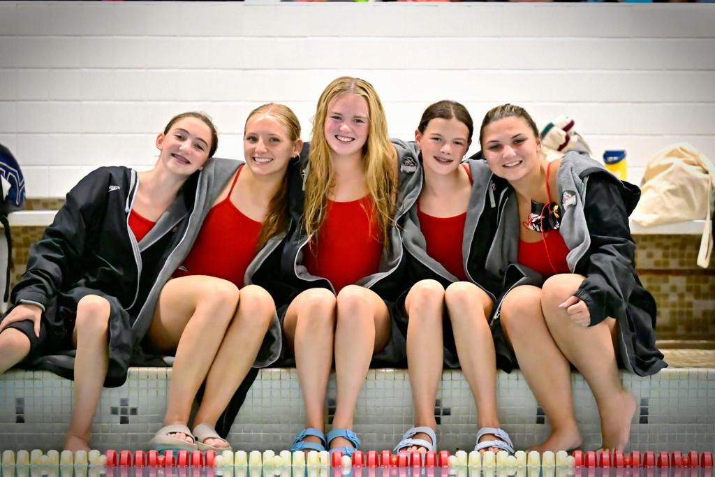 five swimmers on pool deck