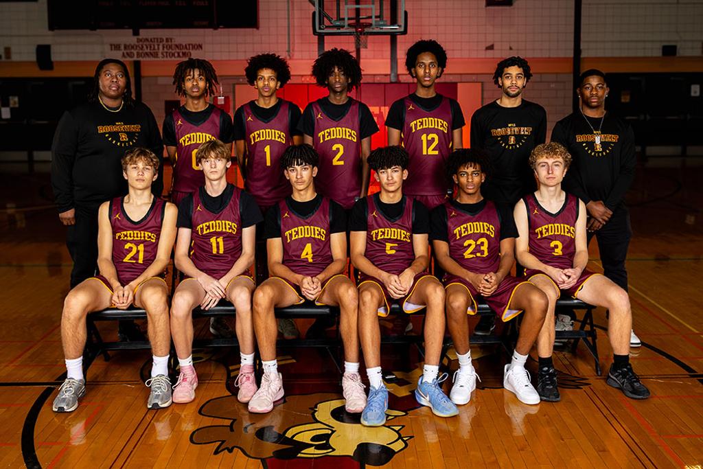 Minneapolis Roosevelt Boys JV team pose in a darkly lit Jack Wells Gymnasium