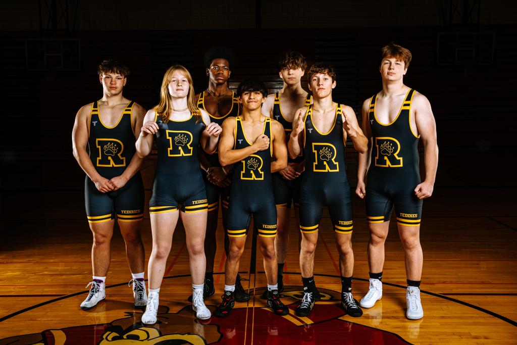 Image of the Minneapolis Roosevelt High School Teddy wrestlers pose in a red colored wrestling room on Teddy Wrestling Media Day