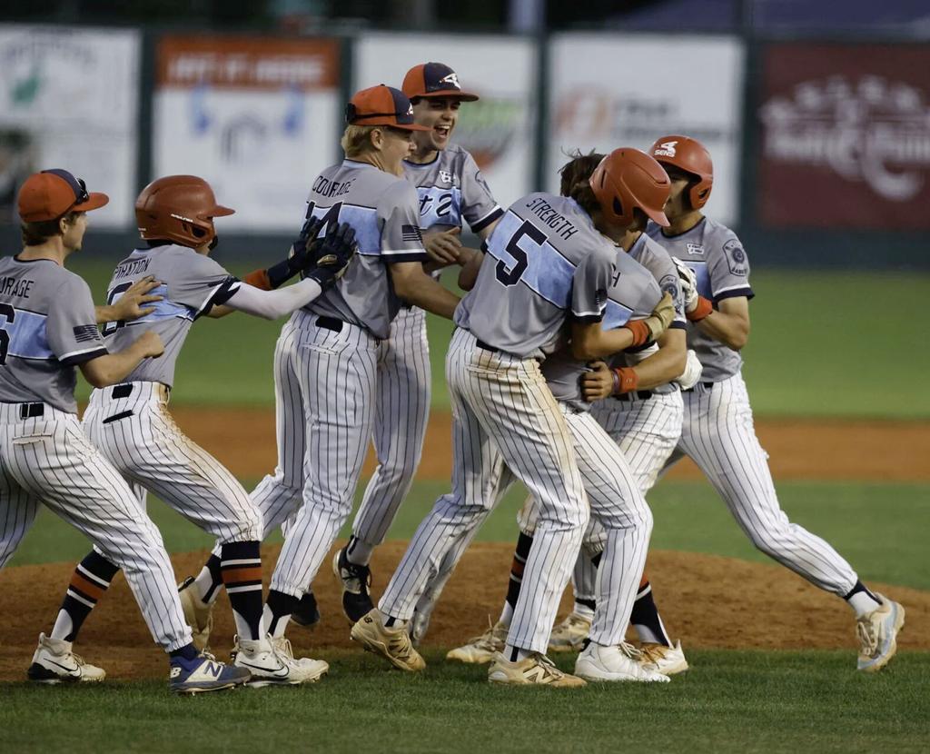   Helena Senators teammates mob Aaron Fuzesy following his ninth-inning walk-off single in a 7-6 victory over the Belgrade Bandits Thursday at Kindrick Legion Field. Fuzesy finished 3-for-5 at the plate with three RBI. Gary Marshall, BMGphotos.com 