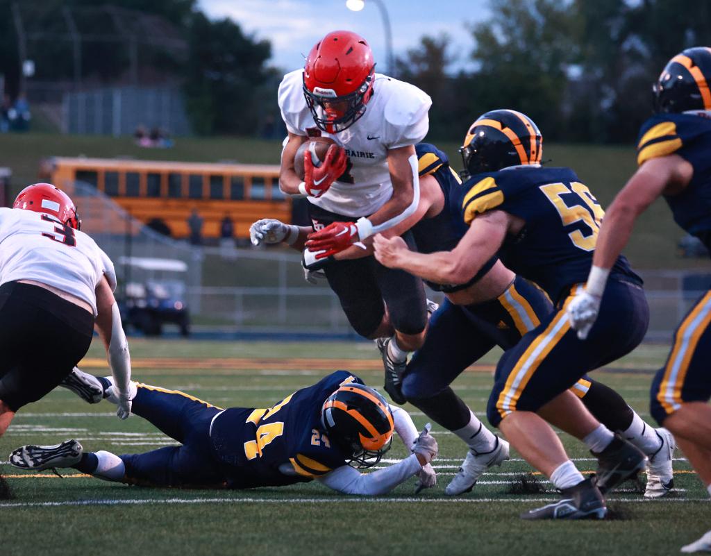 Eden Prairie's Devin Jordan (1) carries teh ball through a trio of Rosemount defenders in the first quarter. Jordan scored the Eagles' only touchdown in the closing minutes of the game. Photo by Cheryl A. Myers, SportsEngine