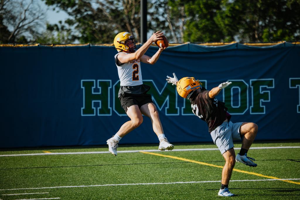 Minneapolis Roosevelt football player leaps to catch a pass during a scrimmage at Blake