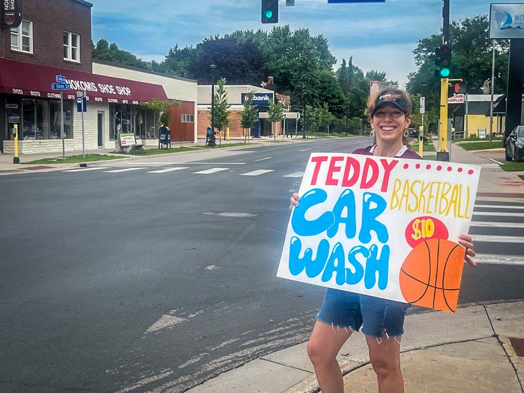 Minneapolis Roosevelt basketball parent holding up a car wash sign on the street corner